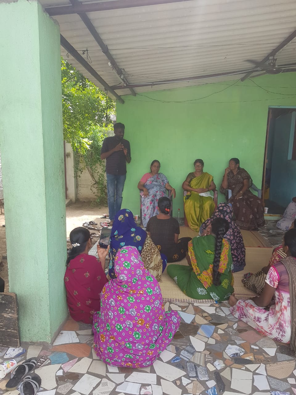 Community awareness meeting with women in a village courtyard